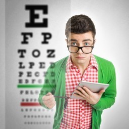 Парень в очках перед таблицей проверяющей зрение - Guy with glasses in front of a table checking eyesight