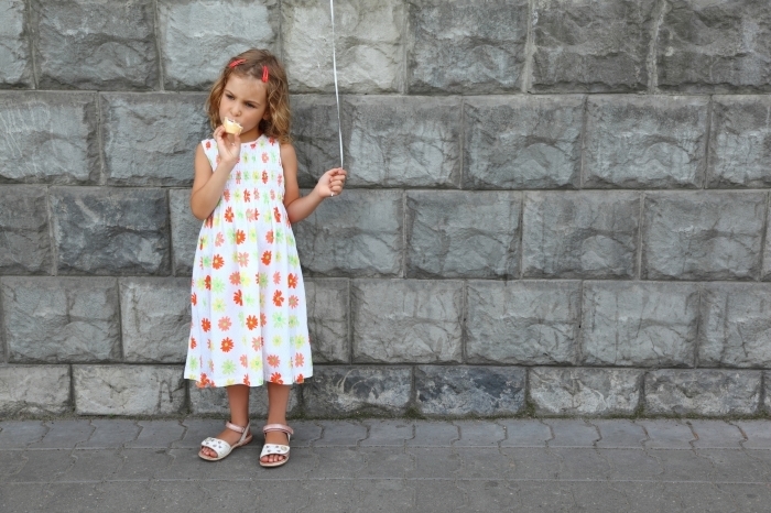 shutterstock 69946483 Девочка с мороженым на фоне стены   Girl with ice cream on a background of a wall