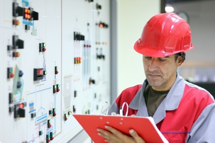 shutterstock 60855814 700x466 Рабочий в каске возле трансформаторов   Work in a helmet near transformers