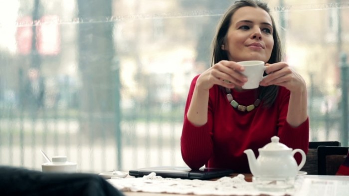 stock footage young beautiful woman with modern laptop drinking tea in cafe 700x393 Девушка с чашкой   Girl with a cup