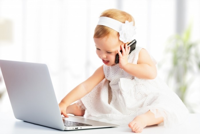 dollarphotoclub 58811166 baby on laptop and phone 700x470 Девочка за ноутбуком и телефоном   Girl of the laptop and phone