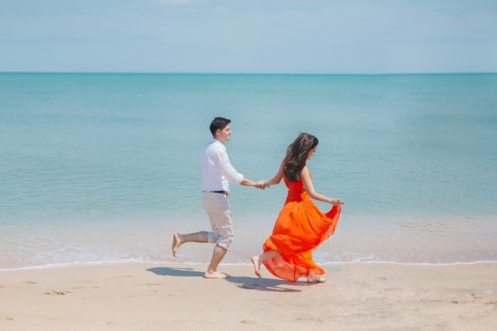  Пара бежит по побережью моря босиком   couple runs along the coast of the sea barefoot